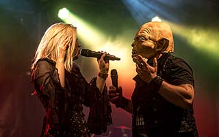 Sänger mit Maske auf im Duett mit Sängerin