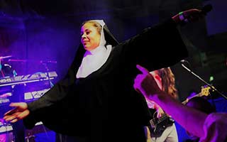 Sängerin als Nonne verkleidet im blauem Bühnenlicht
