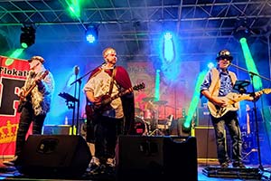 Die Partyband King Seppys Flokatis auf einer Stadtfestbühne im blau/weissem Bühnelicht